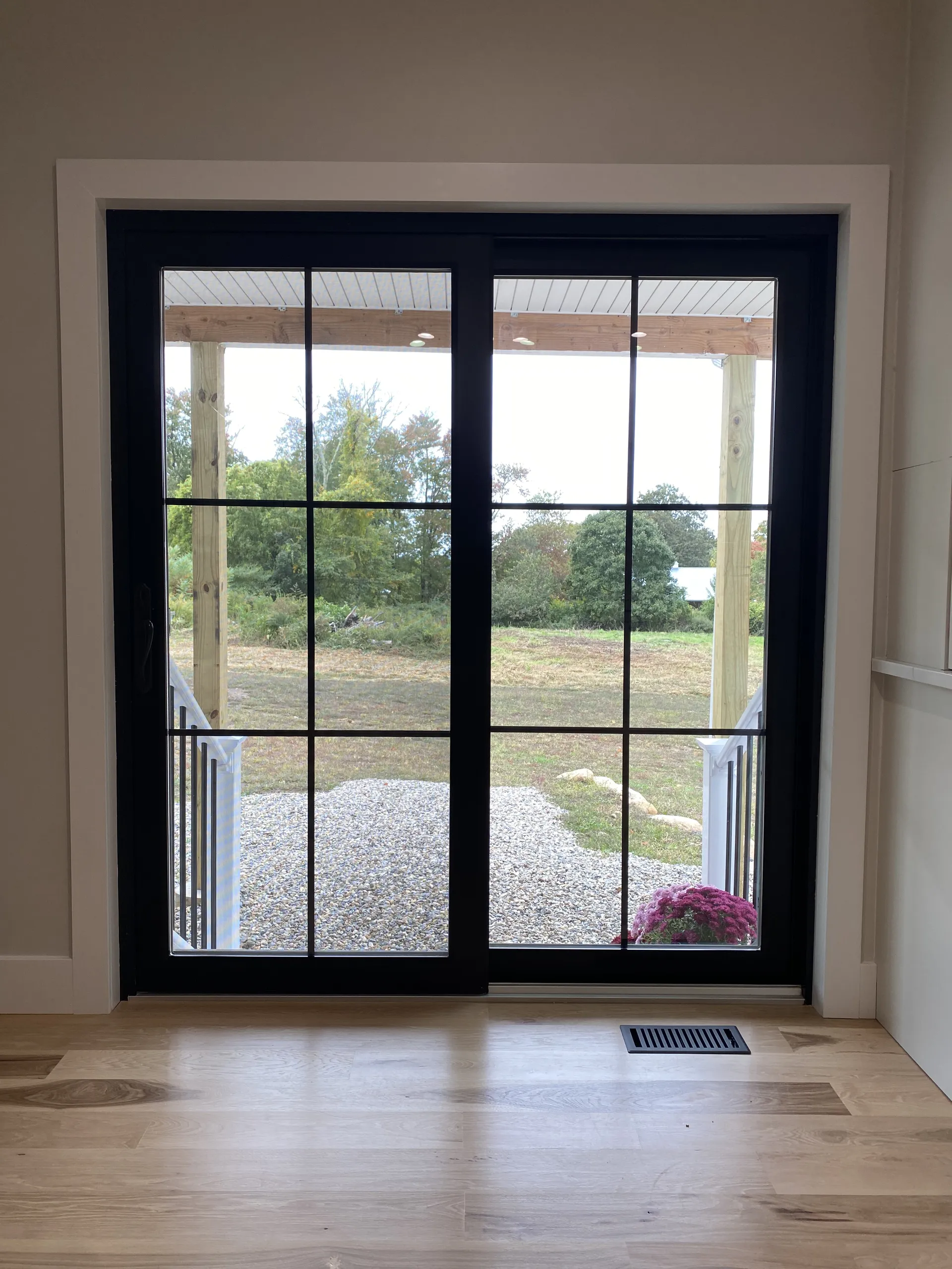 Black sliding French patio door with colonial grilles, seen from inside a Connecticut home